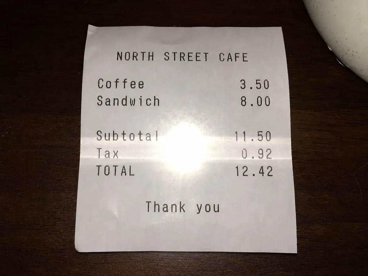 Photo of a paper document with a flash glare hotspot hiding the text