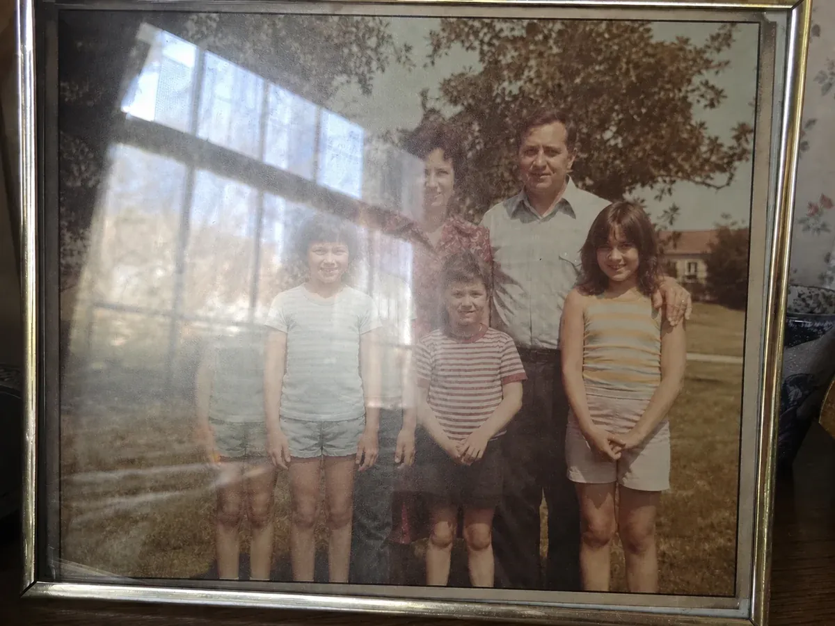 Reprinted old family photo with a sheet of glare across it before AI glare removal